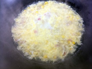 玉米火腿肠蛋茸汤,把鸡蛋液倒进去，不停搅拌，打成蛋花