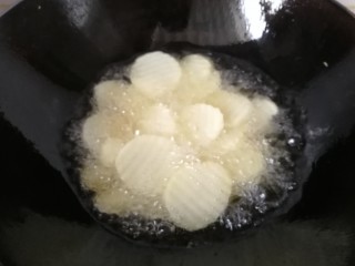 香爆土豆片,锅中倒入适量油烧至六七成热，下入土豆片开始炸
