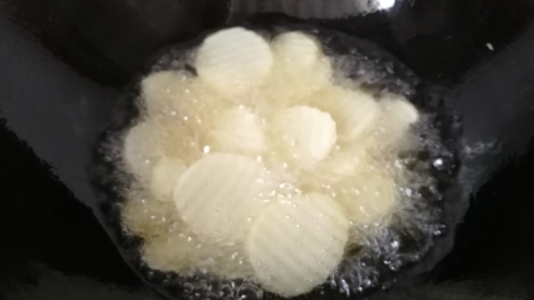 香爆土豆片,锅中倒入适量油烧至六七成热，下入土豆片开始炸