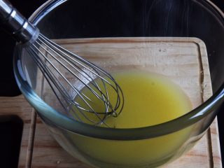 中空南瓜戚风蛋糕,玉米油和南瓜汁放入玻璃碗中，加入盐和细砂糖25克，用蛋抽搅拌油水混合。