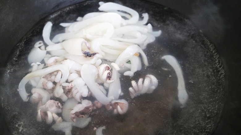 爆炒香辣小鱿鱼制作教程,将水烧开至80度的水温，放入切好的鱿鱼丝，倒入适当的料酒，为了更好的去除鱿鱼的腥味。