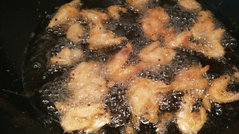 香炸小河虾,用筷子夹出小虾放入锅中炸制。