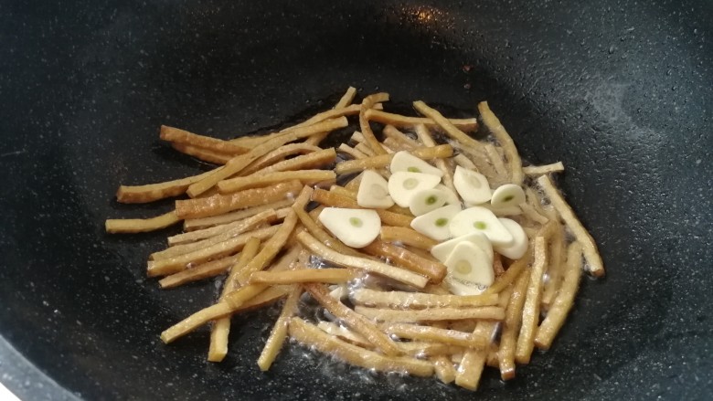 耗油青菜煎豆干,豆腐干煎上色了放入蒜片炒出蒜香味。