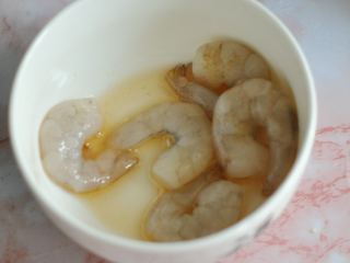 虾仁红米肠粉卷,将虾仁清洗一下，放入碗中，加入料酒和胡椒粉腌制片刻。