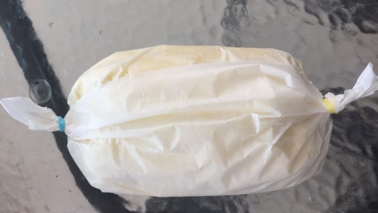 原味千层奶油蛋糕卷,将卷好的千层蛋糕卷放在油纸上包住扎紧，放冰箱冷藏1个小时以上。