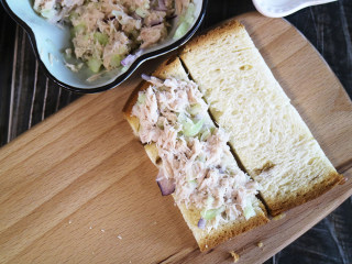 金枪鱼黄瓜三明治,一片吐司上先涂上金枪鱼酱,再盖上片吐司继续涂一层金枪鱼酱。