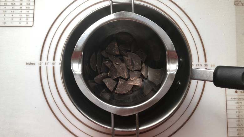 甜甜圈,.巧克力币放到无油无水的容器中，隔热水融化。我是黑白巧克力币各融化了70克，但是没有用完，可以留着下次用。