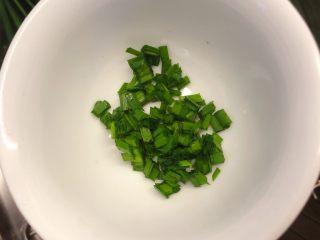 普宁炸豆腐,韭菜切丁放在小碗里。