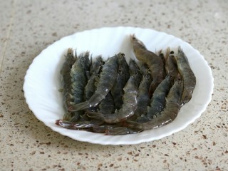 蒜蓉金针菇烤花蛤虾,明虾洗净剪去虾须虾脚，背后剪开挑去沙线，在腹部剪两刀可以防止烤的时候弯曲起来
