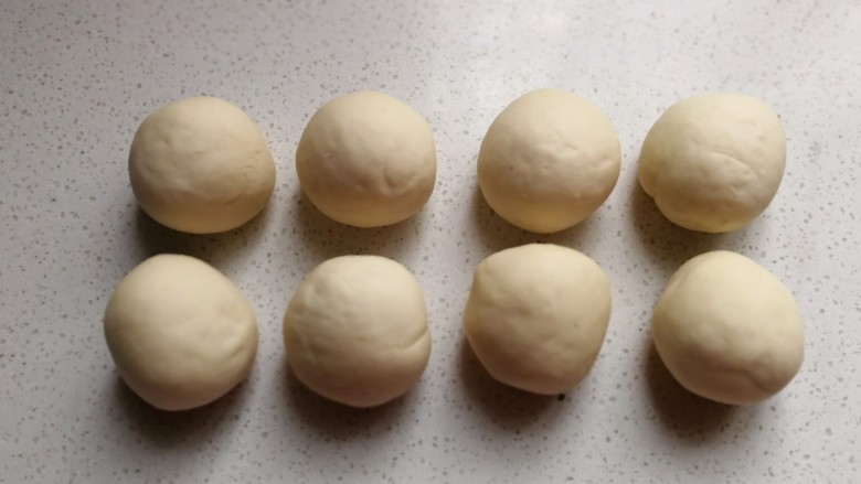 熊猫豆沙馒头,再把剩下的面团分成均匀的八份滚圆，盖保鲜膜静置十分钟左右