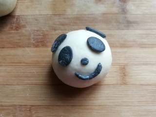 熊猫豆沙馒头,从冰箱取出小配件，按照熊猫的模样把小配件沾点水粘贴起来，再轻轻按压一下