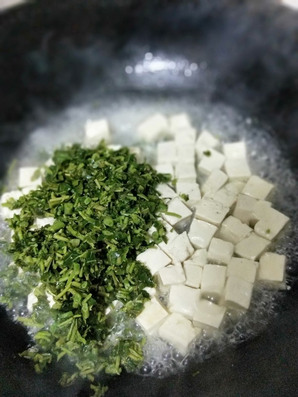 香椿豆腐,倒入焯过水的豆腐和香椿细末。