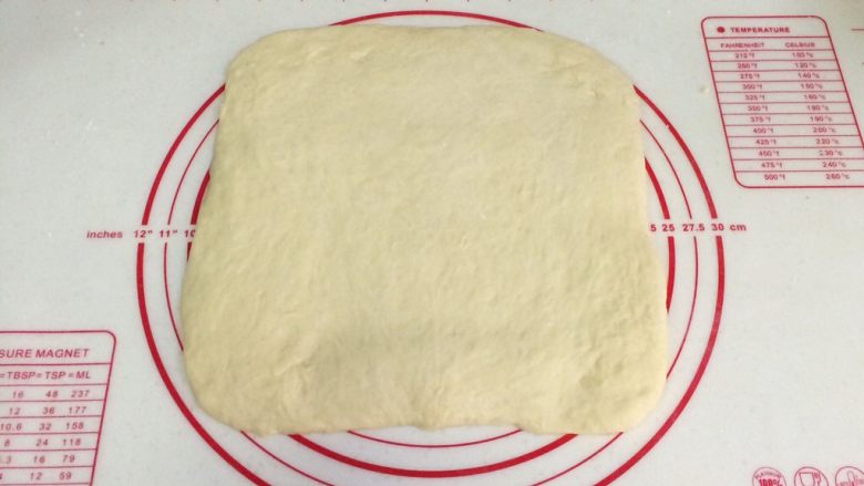蔓越莓方块小面包,把发酵好的面团取出按压排气，可以用擀面杖稍稍擀开排气。