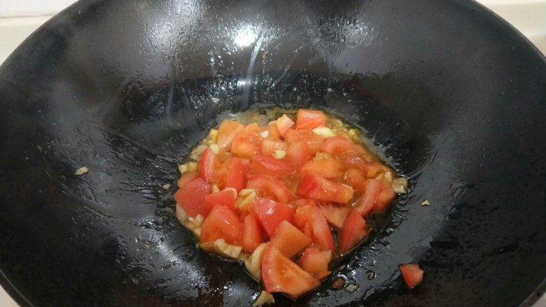 了不起的小番茄＋茄汁火腿金针菇,锅中放入食用油，油温6成时，加入切好的蒜炒香，再把切好的番茄倒入锅中煸炒。