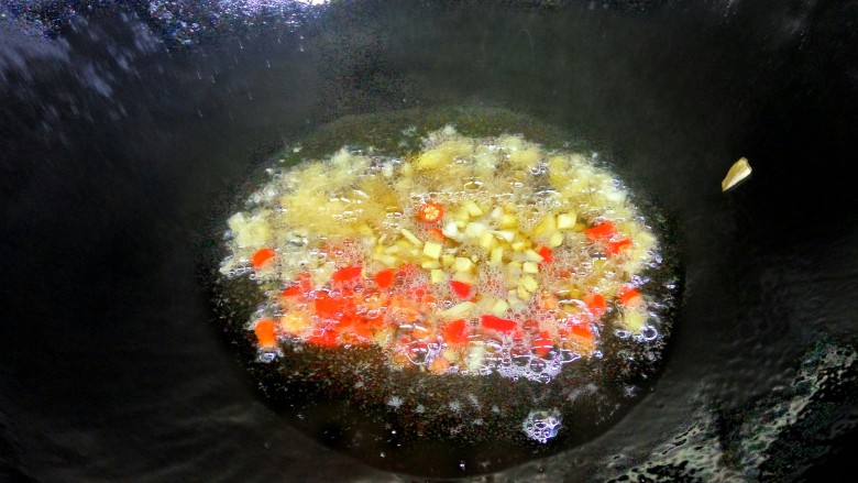 湘味红烧鱼块,另起油锅。将油烧热，将蒜子，姜，小米椒，倒入锅里煸炒。