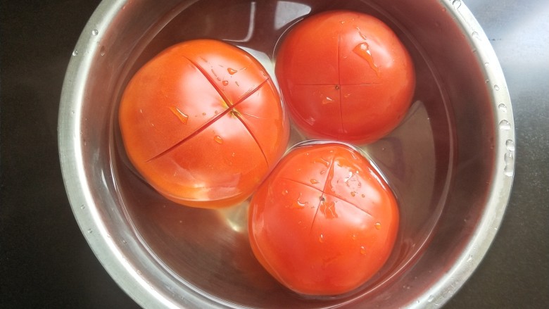 了不起的小番茄   番茄炖黑鱼,番茄划十字，放开水中浸泡。