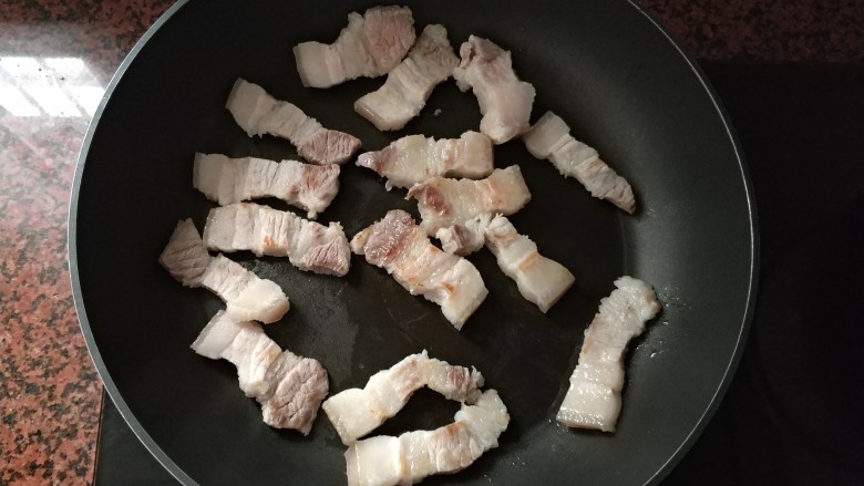 潮汕系列～苦笋煲,平底锅热下，把切好的五花肉，放进去煎至皮变色就可以。