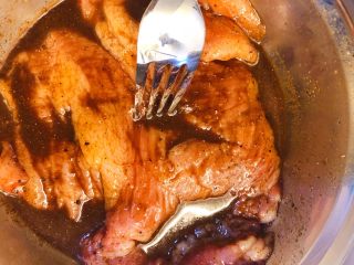 炭烧猪颈肉,用叉子在肉厚的地方多插几个洞，让腌料渗入。