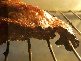 炭烧猪颈肉,翻面后继续放烤箱内烤10-12分钟。
猪肉表面的油脂在细细密密地翻滚，发出吱吱的声音，眼见着一滴滴的油往下掉，这因为有此过程，吃起来才不会那么腻啊。