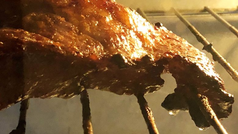 炭烧猪颈肉,翻面后继续放烤箱内烤10-12分钟。
猪肉表面的油脂在细细密密地翻滚，发出吱吱的声音，眼见着一滴滴的油往下掉，这因为有此过程，吃起来才不会那么腻啊。