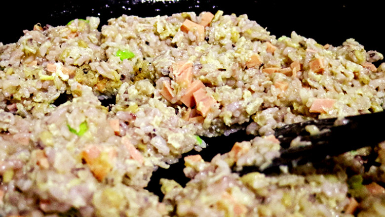 火山岩炒饭,锅中倒入少许油，倒入沾上蛋液的杂粮饭翻炒。