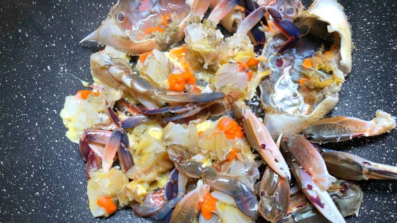 葱姜炒蟹,锅里放入适量油烧热，放入蘸了蛋液的蟹块，中火煎制