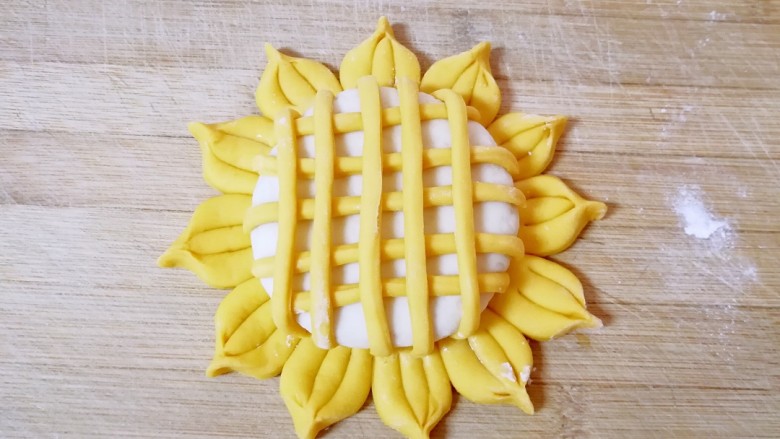 向日葵馒头,多余出来的部分剪掉或者压在白色的圆饼下面，形成网格状。