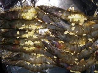 蒜蓉烤大虾,然后把虾摆放在烤盘上，下面垫上锡纸，把蒜末塞到虾里面