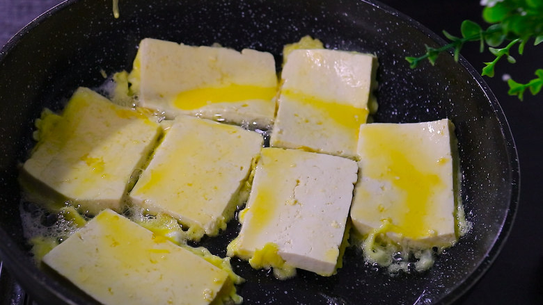 锅塌豆腐,放入沾满蛋液的豆腐片，转中小火煎至两面金黄