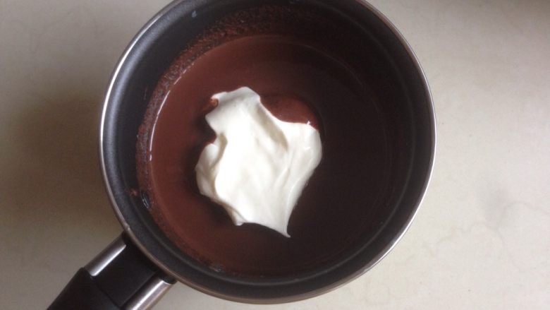 奥利奥巧克力慕斯蛋糕,取少部分打发好的淡奶油，放入到已经冷藏过的巧克力液中拌均匀
