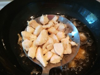 宫爆鸡丁,锅中放适量油烧七成热，放入鸡丁过油，变白色马上捞出来控油。