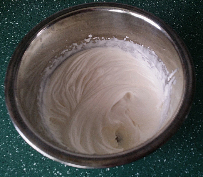 双色卡布奇诺,用电动打蛋器将奶油打至花纹状、装入带有花嘴的裱花袋中