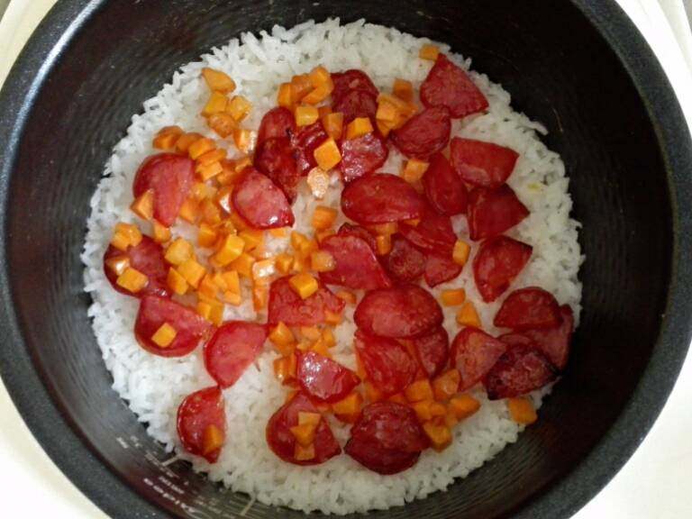蚕豆腊肠焖饭,米饭大约煮到一半的时间加入胡萝卜丁和腊肠
