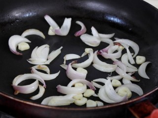 干煸花菜,锅里倒少量的油烧热，将洋葱和大蒜翻炒两下，轻微变色。
