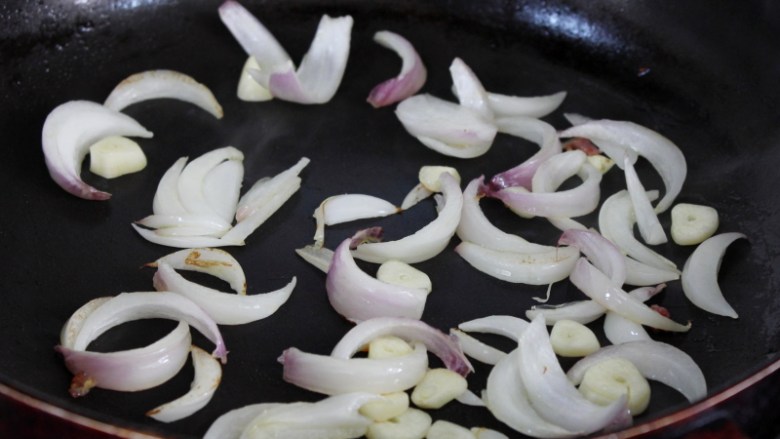 干煸花菜,锅里倒少量的油烧热，将洋葱和大蒜翻炒两下，轻微变色。
