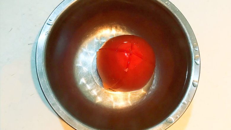 北非蛋,在装有西红柿的盆中加入开水，水量没过西红柿，烫2分钟