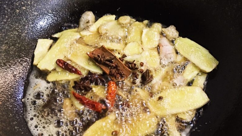 姜母鸭,待到姜片微微焦黄时放入花椒、八角、桂皮炒至香味溢出。