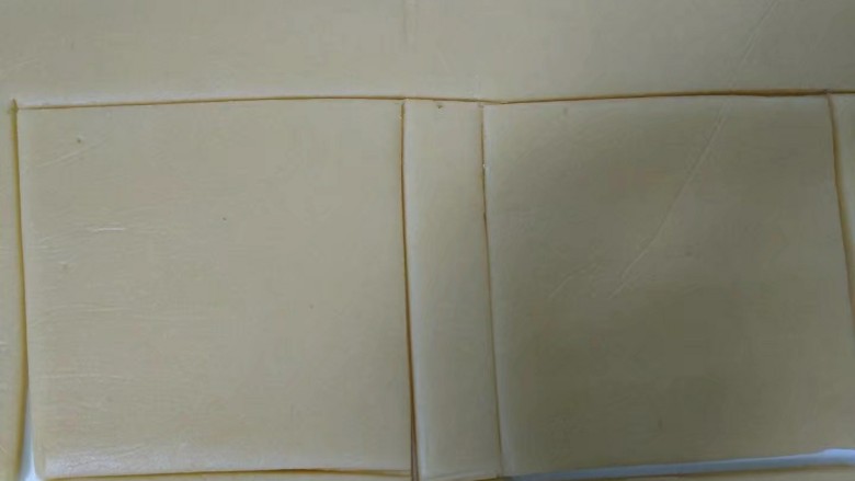糖霜饼干,操作台铺上一张大油纸，将冷藏好的面团放在上面，盖上保鲜膜用擀面杖擀成3mm厚的面皮。（油纸小的话分两次擀）撕去保鲜膜，放上白纸切割出正方形。（这里我只切割6个正方形）