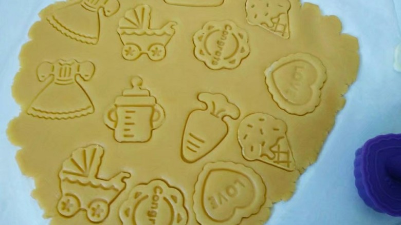 糖霜饼干,剩余的面团放在油纸上，盖上保鲜膜擀成3mm的面片，用饼干模具压出各种形状，去除多余的面片，连同油纸放入烤盘。（这样饼干就不会因移动而变形）