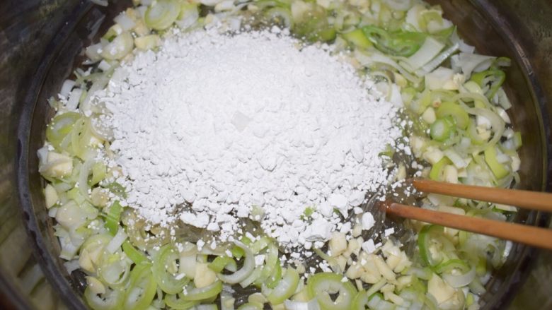 河南小吃——蒸素焖子,粉条煮10分钟即可关火。把葱、蒜和淀粉一块放进去，立即搅拌使葱、蒜、淀粉和粉条均匀混合。