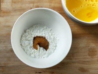油炸劲辣香酥鸡米花,将腌制好的鸡粒先放淀粉碗中滚一圈，用筷子夹起抖一下。