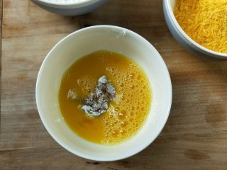 油炸劲辣香酥鸡米花,放入鸡蛋液中浸泡一下，筷子夹起，让蛋液不流淌下来。