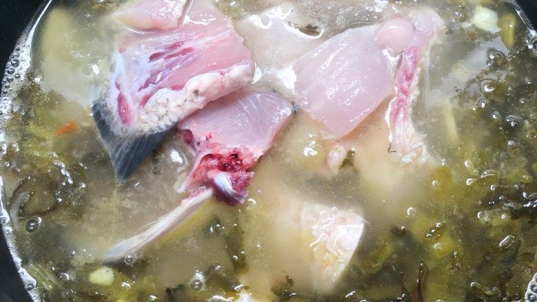 家常酸菜鱼,放入鱼头和鱼骨中火煮3分钟