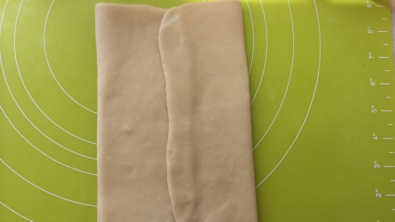 起酥小面包,面片室温回下温，变软后，将两侧面片对折，包裹上黄油，收口处捏紧