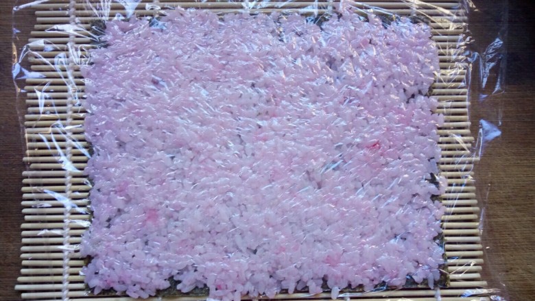 樱花寿司,盖上保鲜膜，用擀面杖来回擀平。