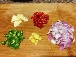小煎鸡,将洋葱切小丁，青椒、辣椒切小圈，大蒜、生姜切片备用。