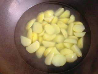 地三鲜,锅中倒入适量清水烧开，下入土豆块煮至八分熟捞出沥干水分。