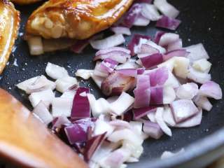 红腐乳烧鸡翅,、接着把鸡翅推到一边，放入切好的洋葱丁煸炒出香味，再将鸡翅和洋葱混合翻炒均匀。