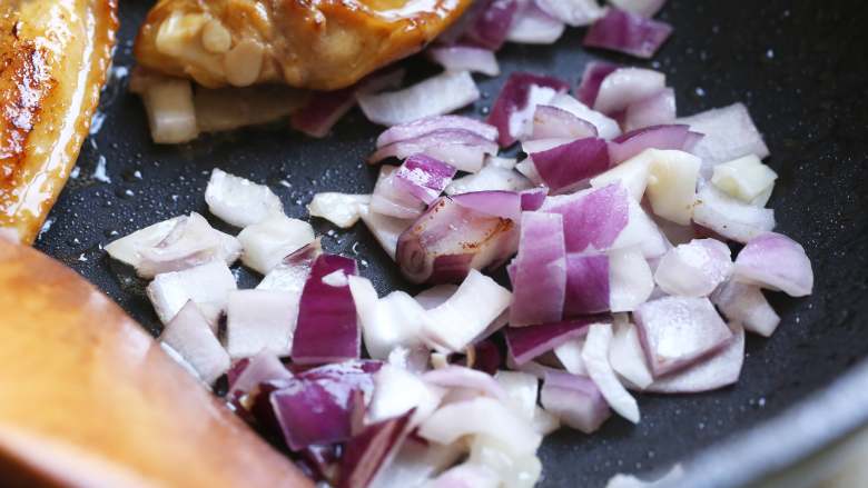 红腐乳烧鸡翅,、接着把鸡翅推到一边，放入切好的洋葱丁煸炒出香味，再将鸡翅和洋葱混合翻炒均匀。