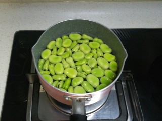春天中的一抹绿-古早盐水蚕豆,我用了一个小奶锅，煮东西很方便，放入蚕豆和水，打开燃气灶。